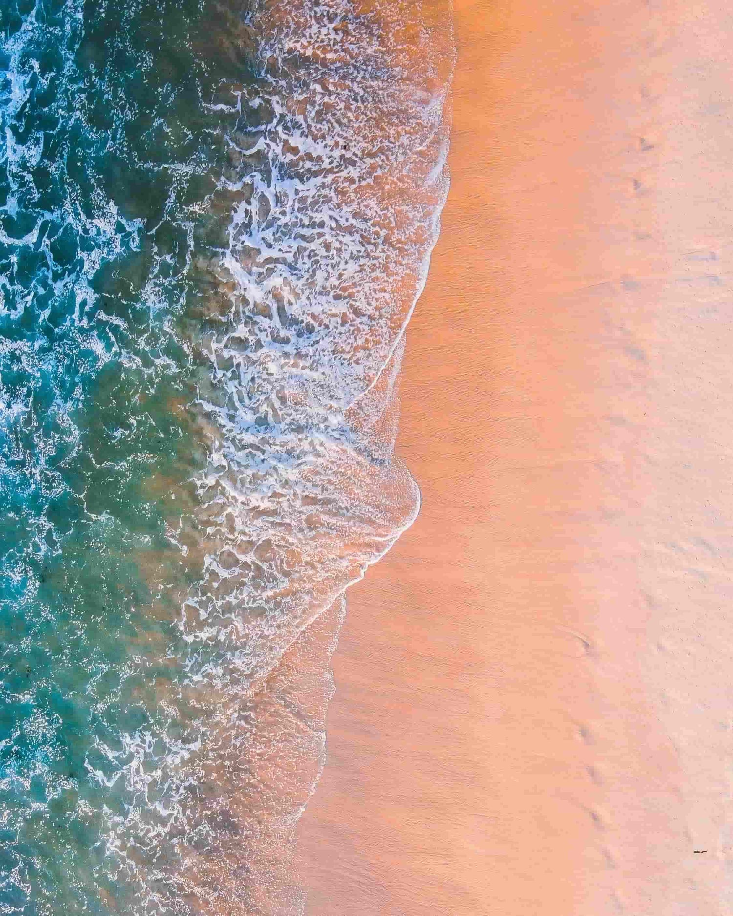 Close-up of ocean waves crashing onto a sandy beach