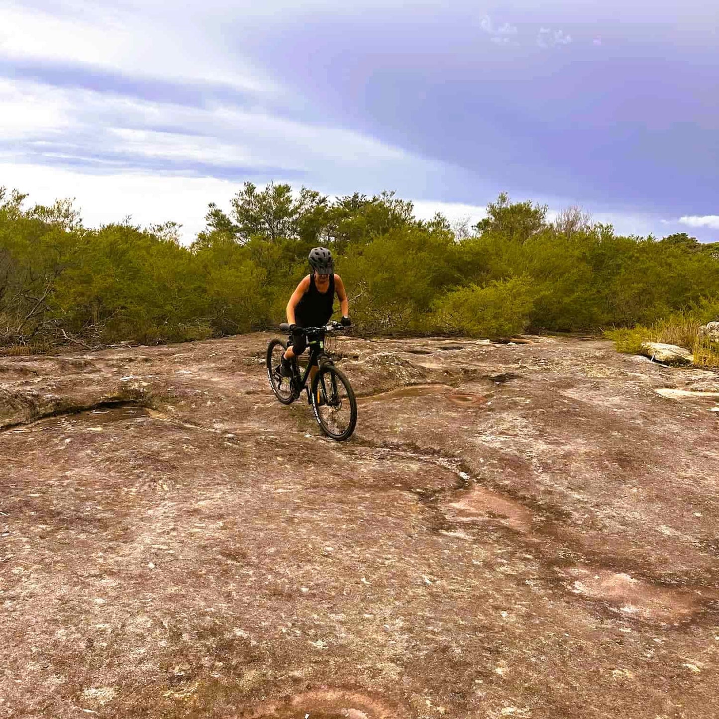 Person riding a mountain bike on a rocky trail at Manly Dam, in Manly Beach on Sydney's Northern Beaches.